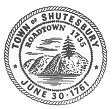 Image of the Official Town Seal of Shutesbury. Pine trees rising over a cliff above a lake. 